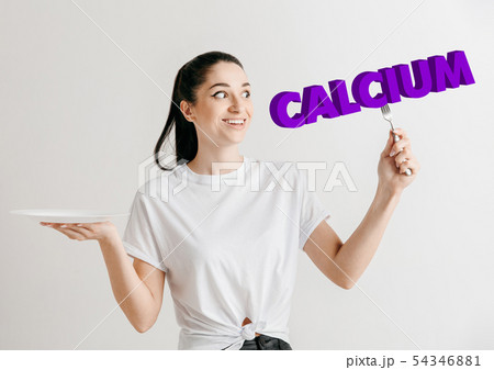 Food concept. Model holding a plate with letters of Calcium 54346881