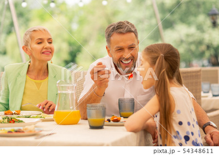 Bearded granddad feeding his lovely cute girl Bearded granddad feeding his lovely cute girl 54348611