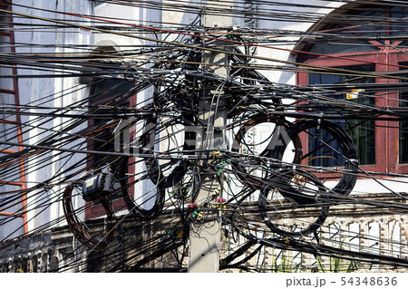 Phone cord on a pole, white building 54348636