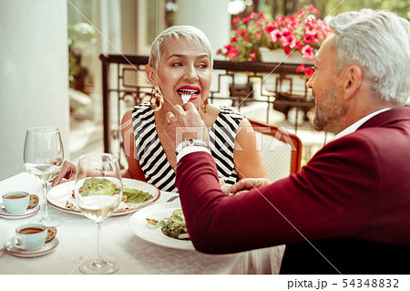 Caring bearded husband giving his wife some salad Caring bearded husband giving his wife some salad 54348832