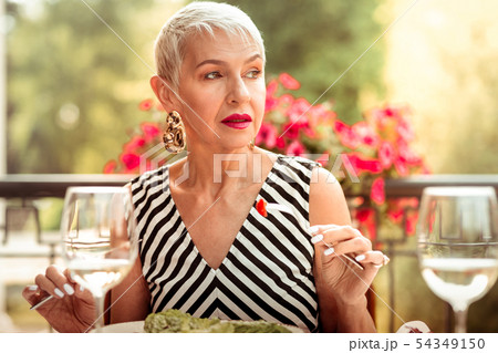 Woman with nice makeup eating salad for dinner outside Woman with nice makeup eating salad for dinner outside 54349150