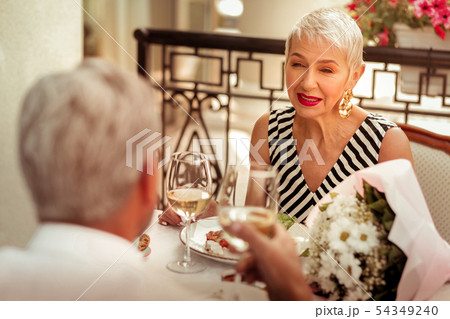 Blonde-haired wife smiling while having romantic dinner with husband Blonde-haired wife smiling while having romantic dinner with husband 54349240