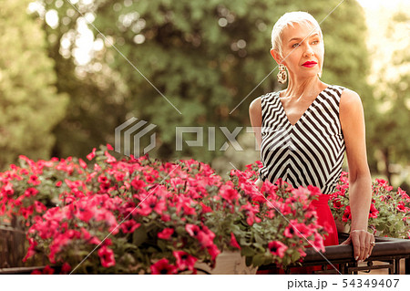 Appealing mature woman wearing nice earrings standing on balcony 54349407