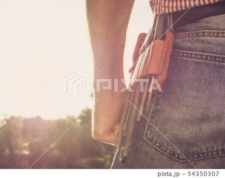 Male hand, blue jeans and vintage belt 54350307