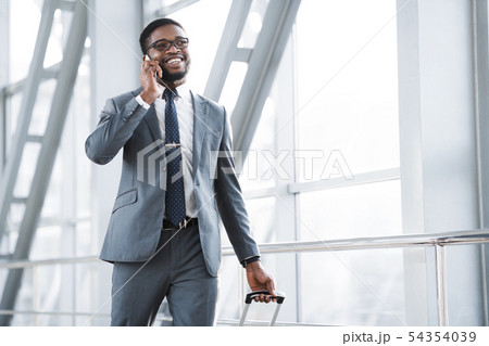 Always in Touch. Busy Man Talking on Phone in Airport 54354039