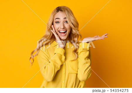 Excited Woman Presenting Something On her Empty Palm Excited Woman Presenting Something On her Empty Palm 54354275