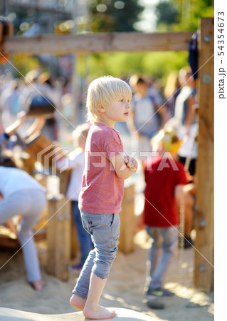 Little boy having fun on outdoor playground of 54354673