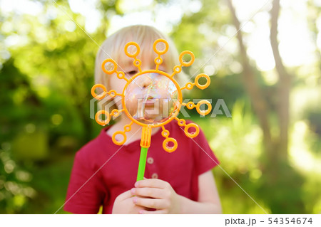 Cute little boy is playing with big bubbles 54354674