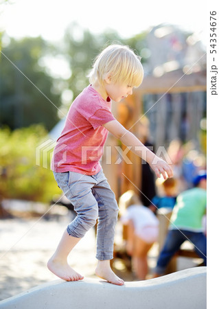Little boy having fun on outdoor playground of 54354676