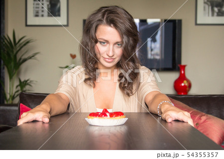 Pretty girl Looking to strawberry cake 54355357