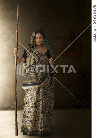 Portrait of woman in sari holding stick 54356176