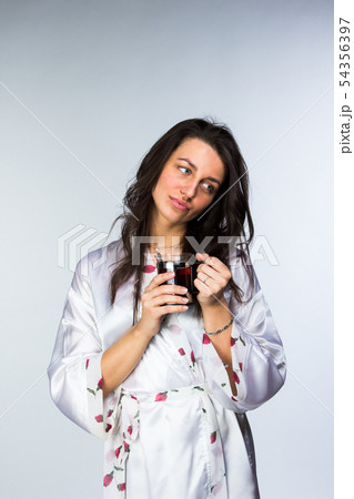 Woman with cup of tea in peignoir early morning 54356397