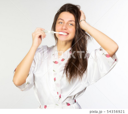 Woman in peignoir with toothbrush 54356921