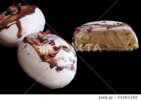 Sliced coffee and chocolate stone desserts with almonds and rose petals on black background Sliced coffee and chocolate stone desserts with almonds and rose petals on black background 54363269