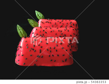 Red watermelon glazed shiny desserts with black sesame seeds and basil leaves isolated on black 54363353