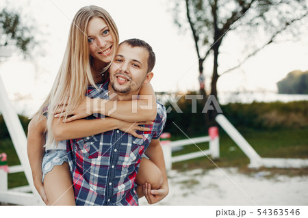 Beautiful couple spend time in a summer park 54363546