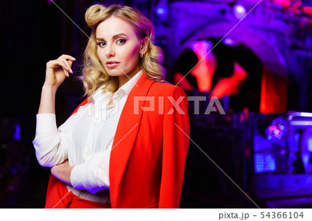 Portrait of young blonde in red suit in nightclub 54366104