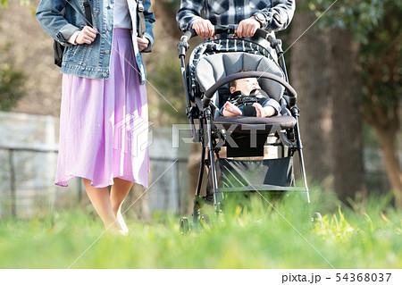 赤ちゃんとベビーカーでお出かけする家族 公園 散歩 子育ての写真素材