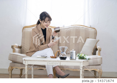女性 ライフスタイル コーヒーを飲みながらスマホ操作 54371674