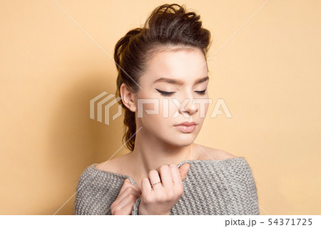 Young beautiful girl with dark hair with a hairstyle a high bunch of makeup, even skin tone with a Young beautiful girl with dark hair with a hairstyle a high bunch of makeup, even skin tone with a 54371725