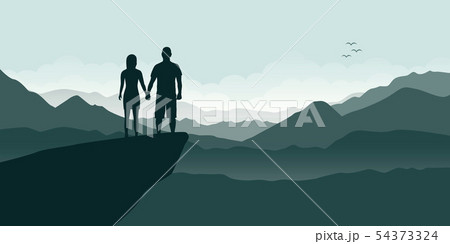 young couple on a cliff enjoy the mountain view 54373324