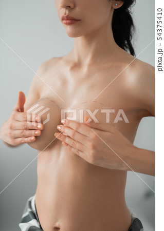 Woman with naked breast waiting for plastic surgeon at clinic Woman with naked breast waiting for plastic surgeon at clinic 54375410