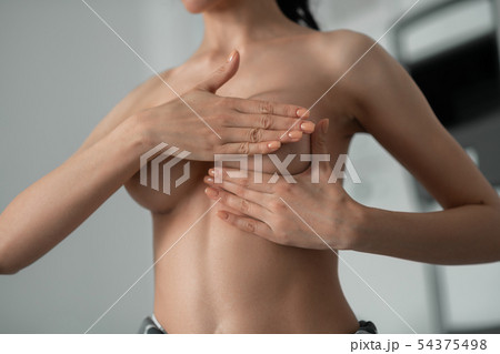 Woman touching her breast before having plastic surgery 54375498
