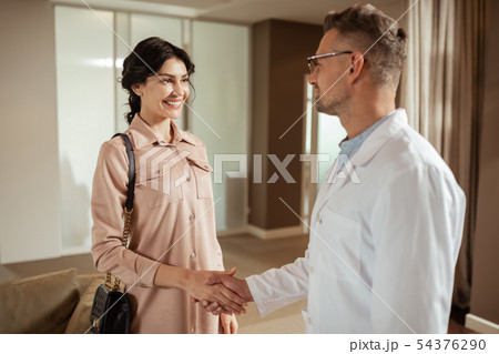 Dark-eyed woman feeling excited while meeting cosmetics surgeon Dark-eyed woman feeling excited while meeting cosmetics surgeon 54376290
