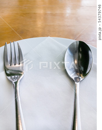 White plate with the silver spoon and fork. 54379746