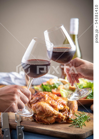 toasting with wine glasses in front of chicken toasting with wine glasses in front of chicken 54381410