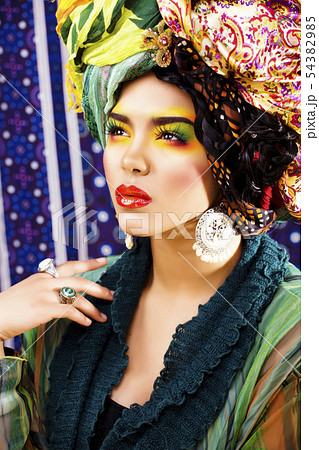 beauty bright woman with creative make up, many shawls on head like cubian, ethno look closeup 54382985