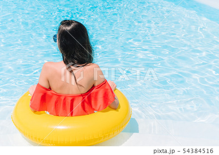 Beautiful young woman relaxing in swimming pool. 54384516