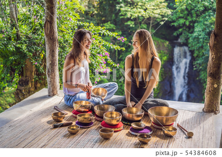 Nepal Buddha copper singing bowl at spa salon. Young beautiful woman doing massage therapy singing 54384608