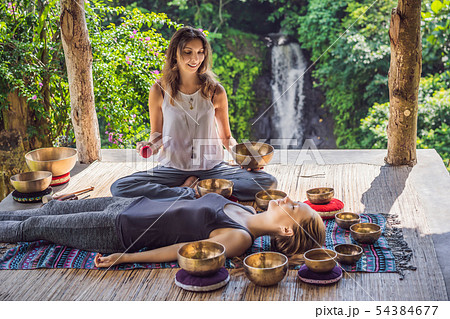 Nepal Buddha copper singing bowl at spa salon. Young beautiful woman doing massage therapy singing 54384677
