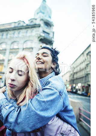Two teenage girls infront of university building smiling, having fun, lifestyle real people concept Two teenage girls infront of university building smiling, having fun, lifestyle real people concept 54385966