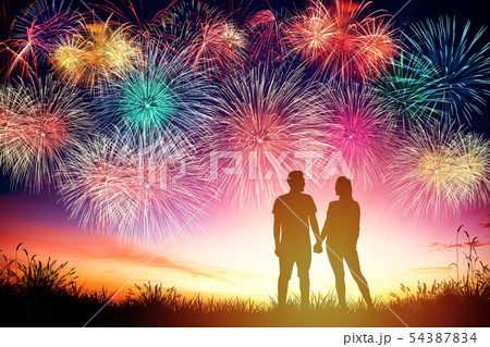 young couple watching fireworks on hill young couple watching fireworks on hill 54387834