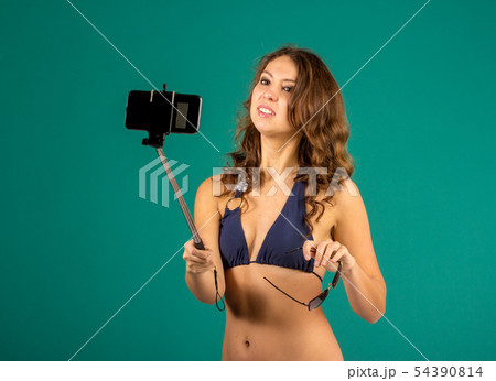 Woman in swimsuits taking a selfie. 54390814
