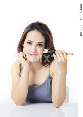 studio shot young woman applying make-up 54392888