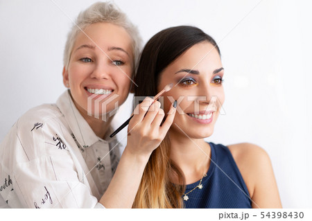 Make-up artist applying bright base color Make-up artist applying bright base color 54398430