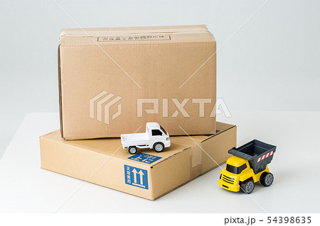 白背景にダンボール箱と車のおもちゃ配送 郵送イメージの写真素材