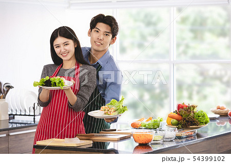 Couple in apron make salad rolls together.. 54399102