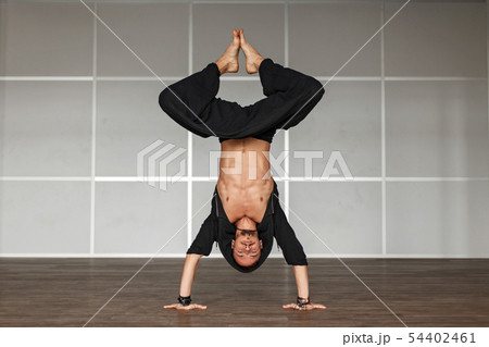 Handsome man in black clothes doing a workout Handsome man in black clothes doing a workout 54402461