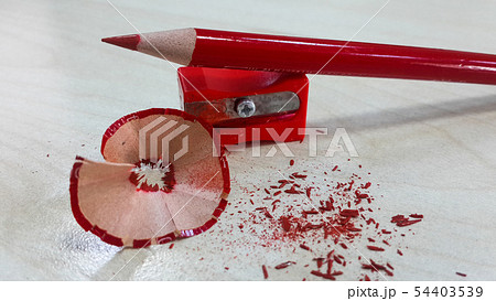 Red pencil and sharpener, isolated on wood backgro 54403539
