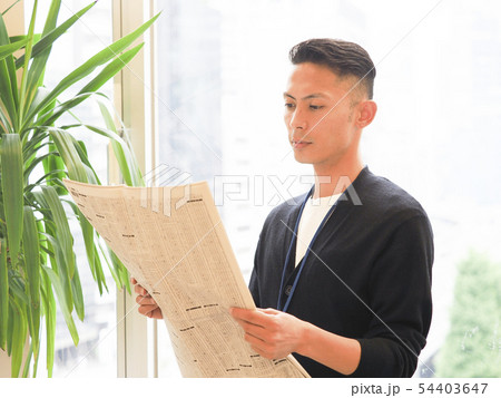 新聞の株式欄を見るビジネスウーマン 54403647