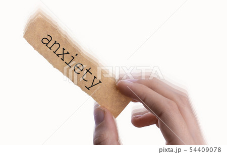 Anxiety wording on blank torn notepaper in hand 54409078