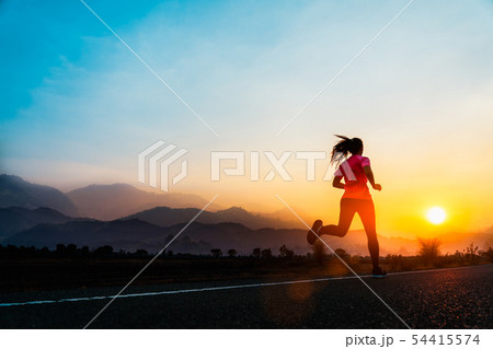 Young woman enjoys running on road. Young woman enjoys running on road. 54415574
