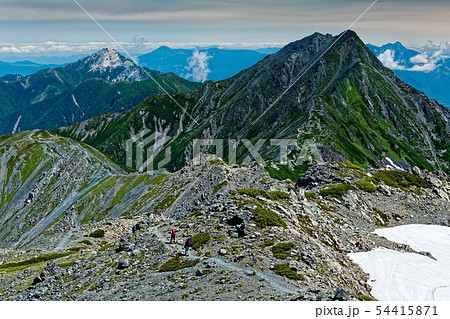 南アルプス・間ノ岳の縦走路を行く登山者と北岳・甲斐駒ヶ岳の眺め 54415871