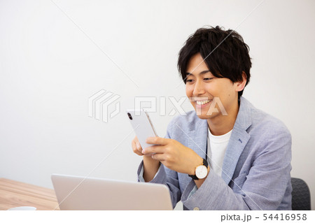 仕事中、彼女からの連絡にニヤける新人社員 54416958