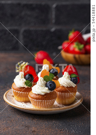 Cupcakes with cream and berries 54418881