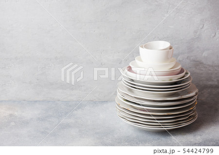 Stack of empty clean plates on a gray table  54424799
